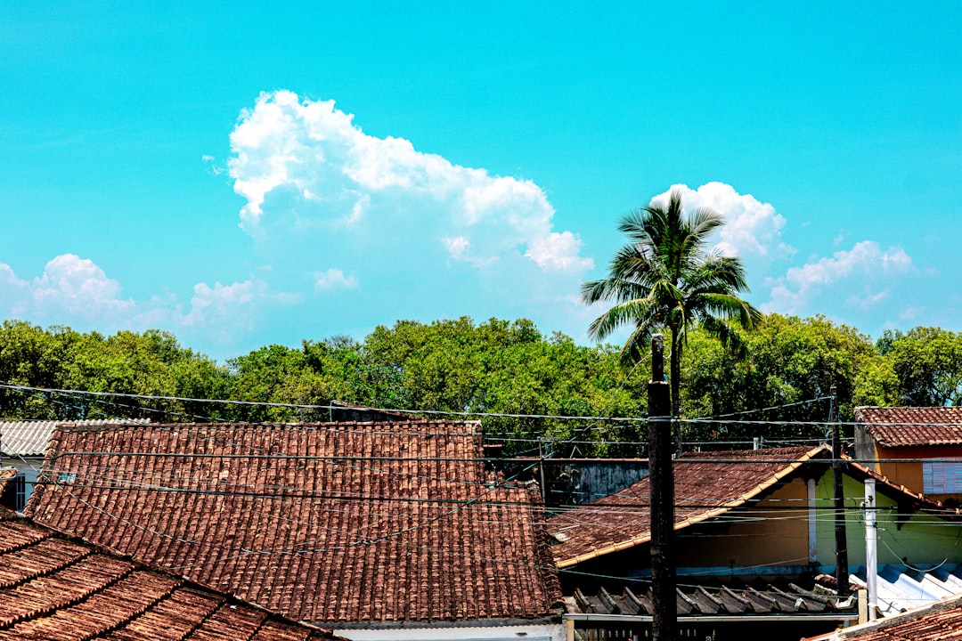 Dark, ominous storm clouds gathering above the roof of a residential house, highlighting the need for a weather-resistant ...