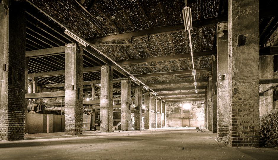 Sunlight streams through the rafters of a hot, unfinished attic, illustrating the problem of heat gain in a home.